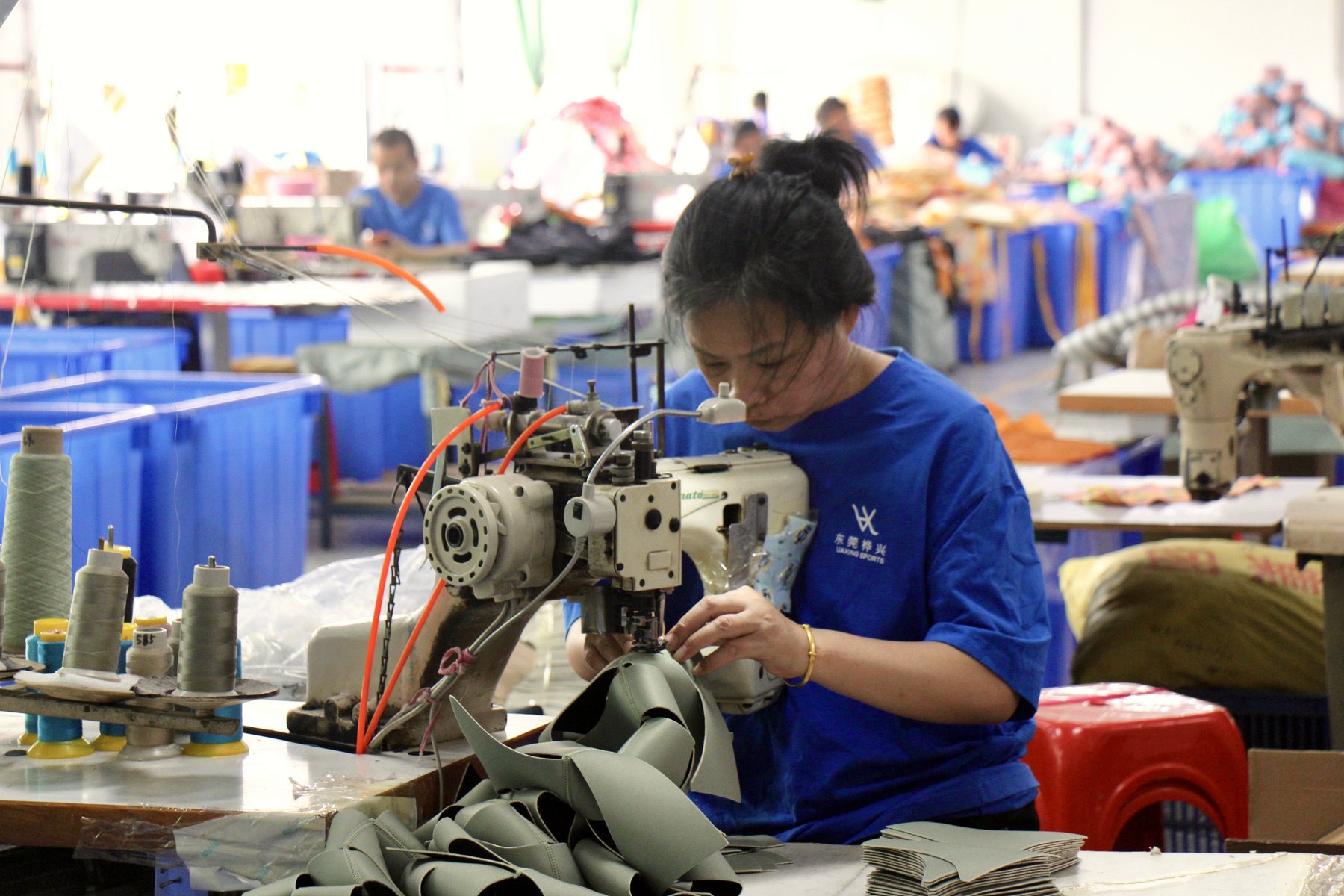 Worker sewing neoprene components on the production line