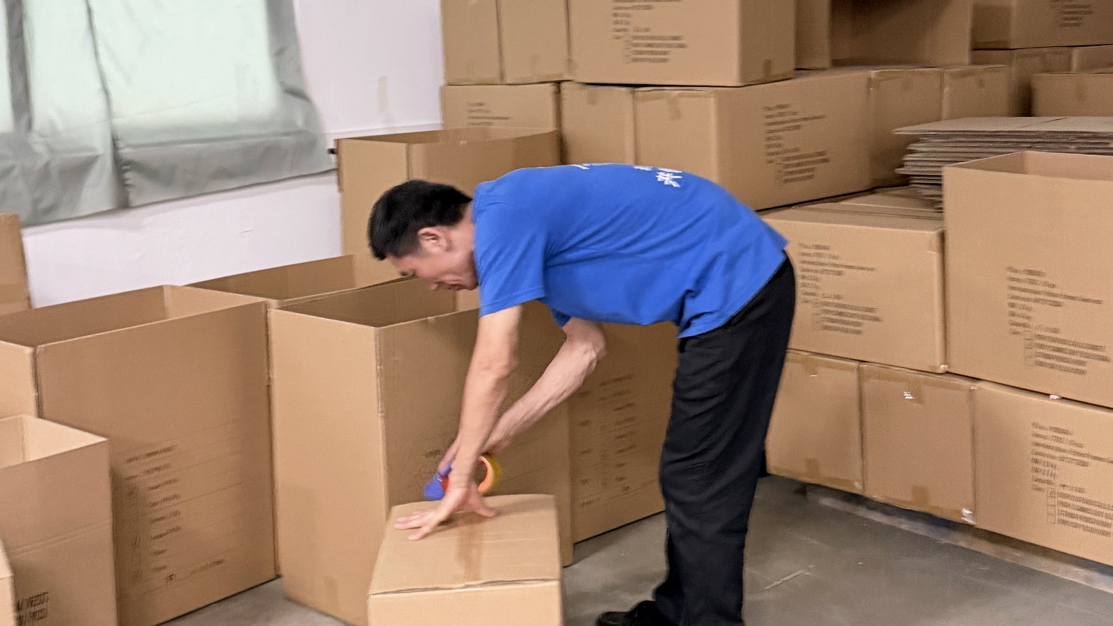 Huatop worker sealing cartons during shipment preparation